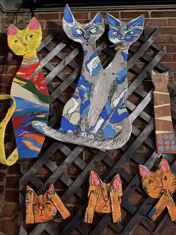 Expressive paper mache cats on the brick wall at Flask lounge by artist Usagii Shain.